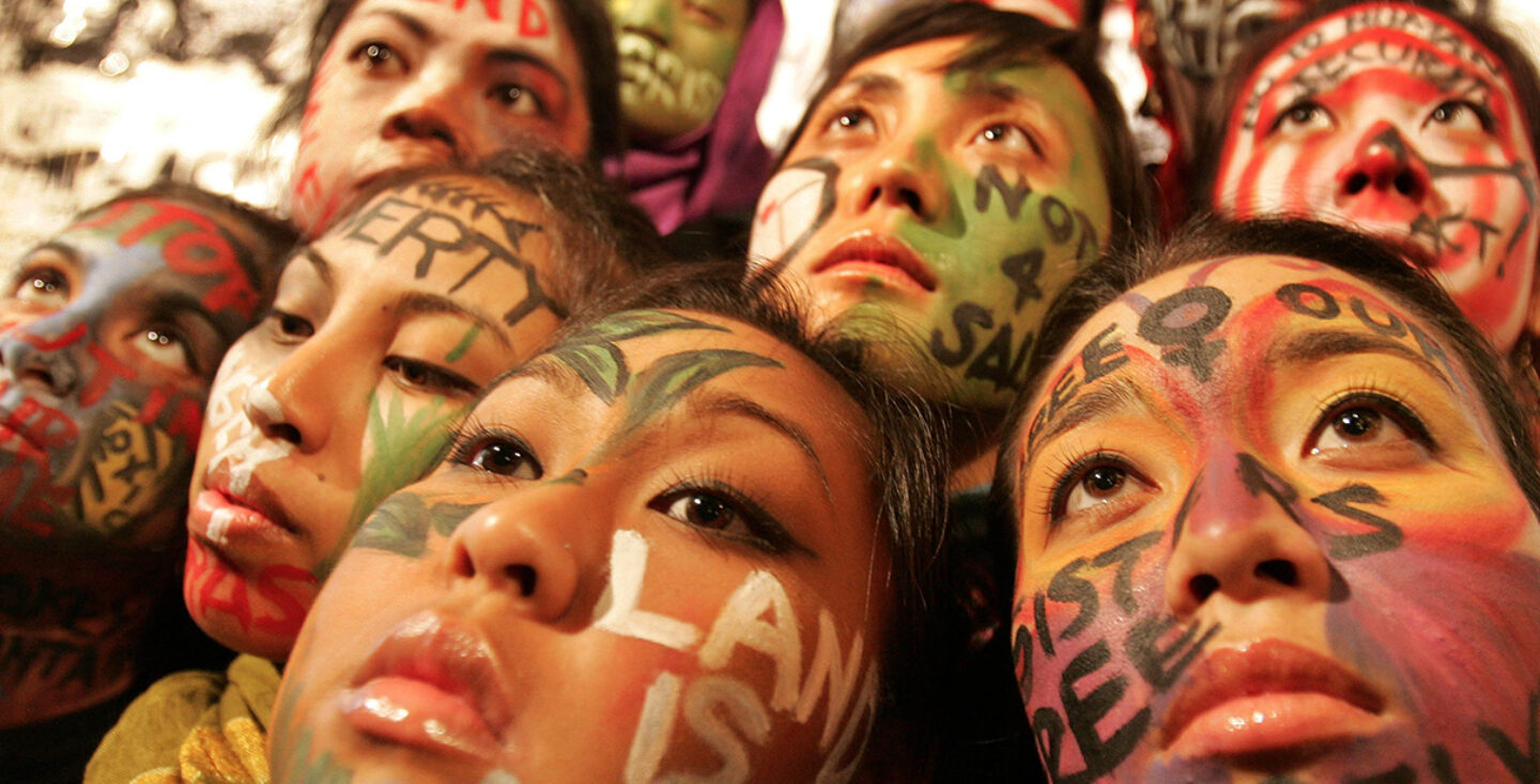close up faces of multiple women with various messages painted on their faces