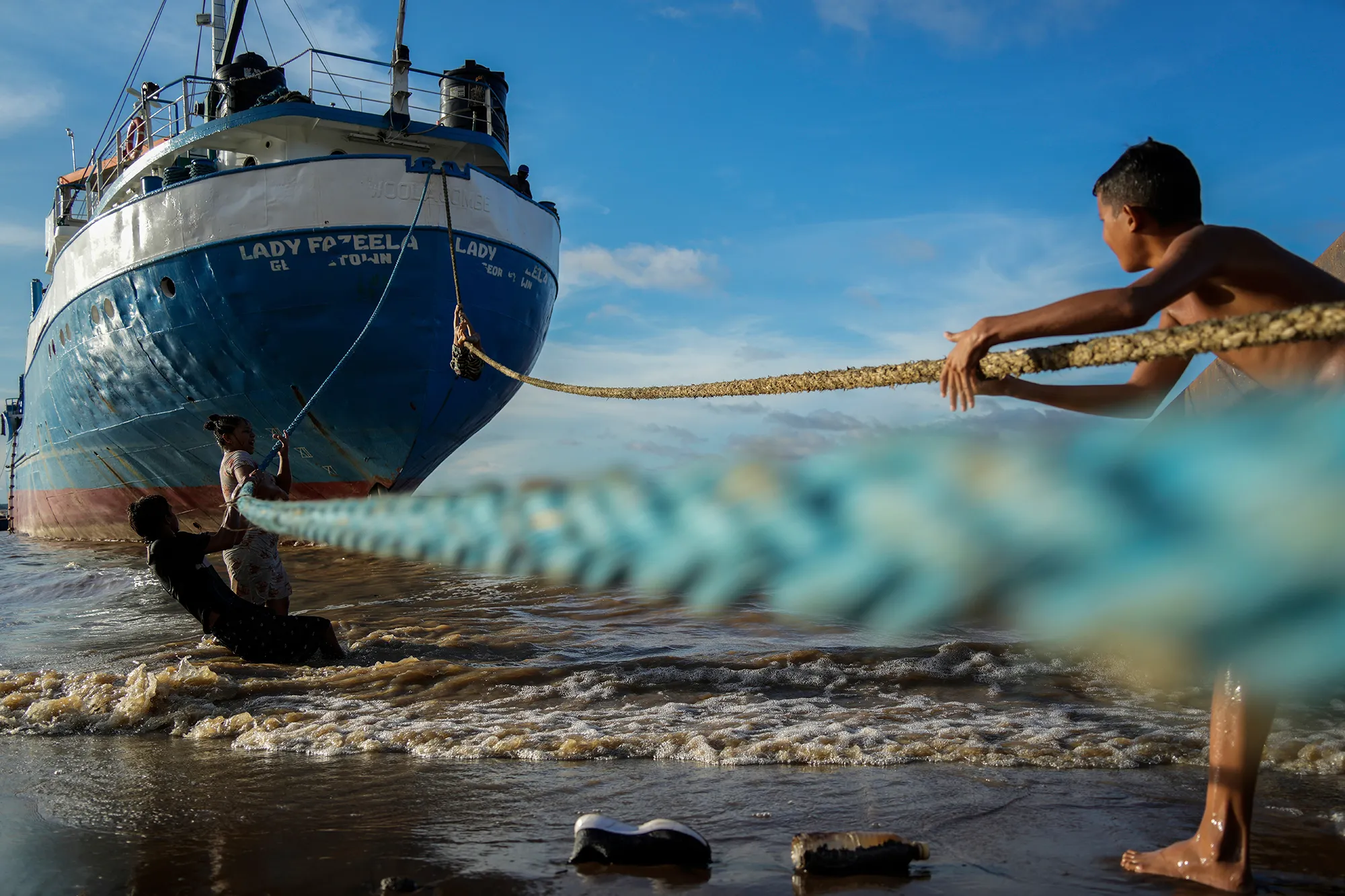 Boy pulling a rope attached to a boat